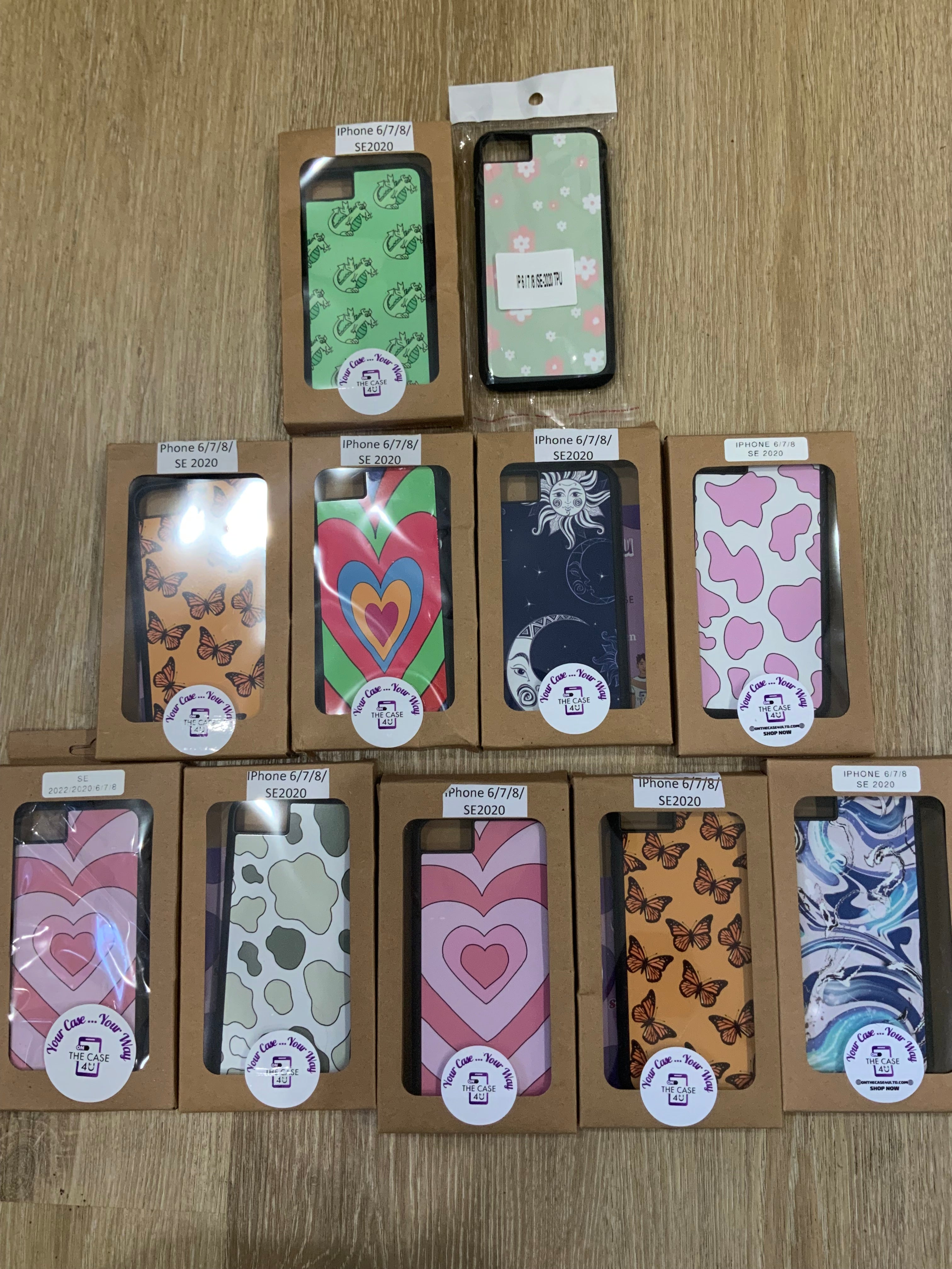 A collection of various premade phone cases for iPhone models displayed in a clearance sale setting, with designs including hearts, floral patterns, and animal prints.