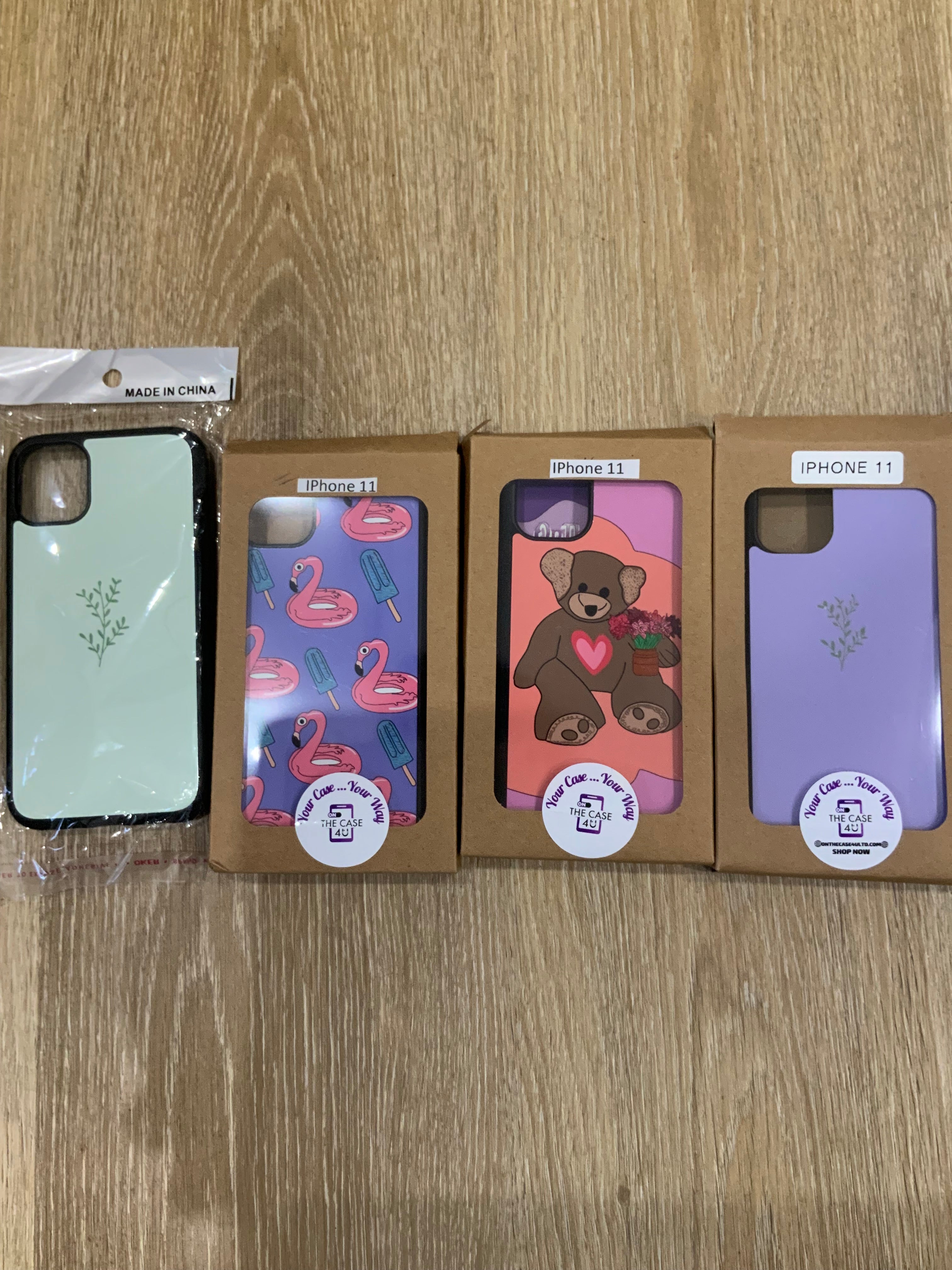 A set of plastic phone cases for iPhone 11 models, displayed in various designs including solid color, animal, and floral patterns.